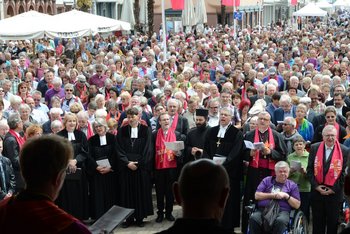 Gemeinsam feiern uns sich begegnen Christen unterschiedlicher Konfessionen stehen im Freien, feiern gemeinsam Gottesdienst und begegnen einander
