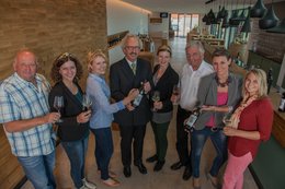 Weinköniginnen mit Dombauvereinsvorsitzendem Wolfgang Hissnauer halten Weingläser und Weinflaschen des neuen Domweins in der Hand.